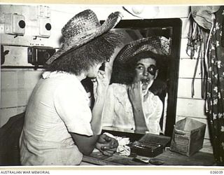 PAPUA, NEW GUINEA. 1942-07. ADDING TO "HER" MAKE-UP, IS THE BAD GIRL-OR THE HUSSY - IN THE MELODRAMA PRESENTED FOR THE ENTERTAINMENT OF AUSTRALIAN AND AMERICAN TROOPS SERVING IN PAPUA BY A GROUP OF ..