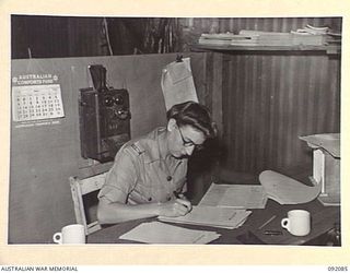 LAE, NEW GUINEA, 1945-05-21. PRIVATE L. KNAUF, AUSTRALIAN WOMEN'S ARMY SERVICE CHECKING BIN TALLY CARDS AT THE AUSTRALIAN ARMY CANTEENS SERVICE, CANTEEN BULK STORE ON BUSU ROAD