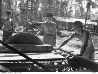 NADZAB, NEW GUINEA. C. 1944-02. LEADING AIRCRAFTMAN (LAC) J. COPEMAN, SERVICETOWN, VIC, AND LAC R. A. MINNS, GRANVILLE, NSW, WORKING A CIRCULAR SAW IN A SAWMILL OPERATED BY NO. 62 MOBILE WORKS ..