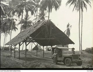 AITAPE, NORTH EAST NEW GUINEA. C. 1944-06. A RAAF JEEP PASSES OVER A COVERED BRIDGE IN THE AITAPE AREA. A ROOF CONSTRUCTED WITH LOCAL MATERIALS HAS BEEN POSITIONED OVER THE BRIDGE