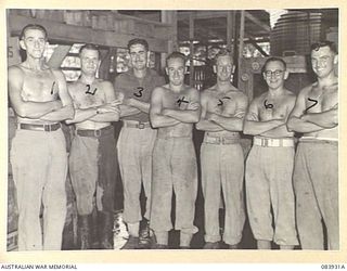 LAE, NEW GUINEA. 1944-12-12. THE SOLDIER STAFF UNDER THE COMMAND OF LIEUTENANT C.J. MULLENS, ARMY CANTEENS SERVICE, (5), AT A SOFT DRINK FACTORY WITHIN LAE BASE SUB-AREA. IDENTIFIED PERSONNEL ARE:- ..