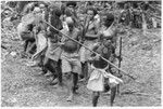 Elota, the priest, circles the dancers 8 times ritually; note pig skull on his left hip