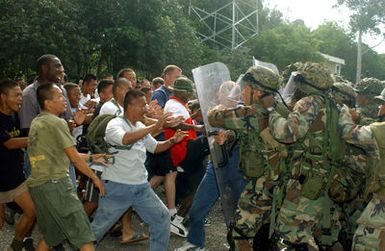 US Marine Corps (USMC) personnel and Royal Thai Marines stop non friendly nation mock protesters in their attempt to stop friendly nation evacuees from reaching the mock embassy during a Non-Combatant Evacuation Operation (NEO), part of Exercise COBRA GOLD 2003. The US Marine Corps (USMC) personnel are attached to 1ST Battalion, 3rd Marines home based from Hawaii