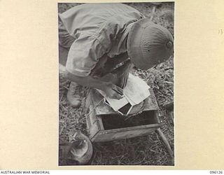 MUSCHU ISLAND, NEW GUINEA. 1945-09-11. A JAPANESE OFFICER MAKING ENTRIES IN HIS RECORD SHEETS. HE IS A JAPANESE CIVILIAN WITH THE HONORARY RANK OF MAJOR IN THE ARMY. HE CONTROLS THE FISHING BY ..