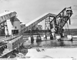 NAURU, PACIFIC OCEAN. 1941. PHOSPHATE CANTILEVER LOADING EQUIPMENT DAMAGED BY SHELLFIRE FROM THE GERMAN RAIDER KOMET ON 1940-12-27. (NAVAL HISTORICAL COLLECTION)