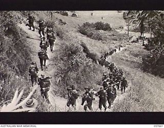 KAIAPIT, NEW GUINEA. 1943-09-27. "D" COMPANY, 2/31ST AUSTRALIAN INFANTRY BATTALION, 7TH AUSTRALIAN DIVISION GOING UP TO POSITIONS ABOVE KAIAPIT VILLAGE TO COVER THE ADVANCE OF THE 21ST AUSTRALIAN ..