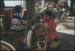 Papeete waterfront: woman making flower garlands
