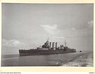 WEWAK HARBOUR, NEW GUINEA. 1945-11-25. HMAS SHROPSHIRE LEAVING THE HARBOUR CARRYING 590 TROOPS OF 6 DIVISION WHO ARE RETURNING TO AUSTRALIA FOR DISCHARGE