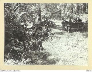BOUGAINVILLE ISLAND. 1945-02-17. TROOPS OF C COMPANY, 61ST INFANTRY BATTALION RESTING AT THE YOUNG MEN'S CHRISTIAN ASSOCIATION - AUSTRALIAN COMFORTS FUND JEEP AT MEIVO JUNCTION AFTER THEY HAD ..