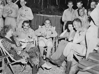 TADJI NEAR AITAPE, NORTH EAST NEW GUINEA. C. 1944-10. INFORMAL GROUP PORTRAIT OF NO. 8 (BEAUFORT) SQUADRON RAAF ENTERTAINING MEMBERS OF JUDITH ANDERSON'S CONCERT PARTY AT SUPPER AFTER THEIR SHOW. ..