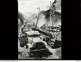NADZAB, NEW GUINEA. C. 1944-02. STONE CRUSHING MACHINE OF NO. 62 MOBILE WORKS SQUADRON RAAF IN ACTION CRUSHING RIVER BALLAST FOR FOUNDATION OF AN AIRSTRIP. THE DUSTIEST JOB IN THE RAAF
