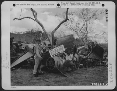Pvt. William V. Bernbaum, Brooklyn, N.Y., of the 409th Service Squadron, 8th Service Group, standing guard at an American plane salvage yard at an airdrome near Port Moresby, Papua, New Guinea. 2 November 1942. (U.S. Air Force Number 77819AC)