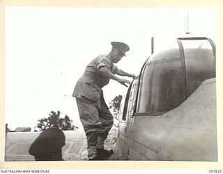 PIVA AIRSTRIP, TOROKINA, BOUGAINVILLE, 1945-05-09. LT-GEN V.A.H. STURDEE, GOC FIRST ARMY, CLIMBS FROM A BEAUFORT AIRCRAFT ON HIS ARRIVAL FOR A TOUR OF INSPECTION OF TROOPS ENGAGED IN OPERATIONS ON ..