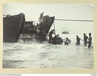 TOKO, BOUGAINVILLE, SOLOMON ISLANDS. 1945-03-20. NATIVES ASSISTING PERSONNEL OF THE 9TH INFANTRY BATTALION TO UNLOAD FROM THE LCT (LANDING CRAFT TANK). TRUCKS AND STORES WERE PULLED BY WINCH ..