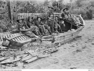 KALIMBOA, AITAPE- WEWAK SECTOR, NEW GUINEA. 1945-04-26. 2/3RD INFANTRY BATTALION TROOPS RESTING ON THE WRECK OF A JAPANESE BARGE. IDENTIFIED PERSONNEL ARE:- PRIVATE J.M. ABERNETHY (1); PRIVATE E.J. ..