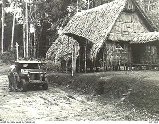 ILOLO - OWERS' CORNER, NEW GUINEA. 1944-04-12. NEWTON'S DUMP, A SIGNAL STATION OPERATED BY THE 18TH AUSTRALIAN LINES OF COMMUNICATION SIGNALS. ALONGSIDE THE HUT AND TO THE RIGHT OF THE JEEP IS A ..