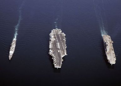 (From right-to-left), Aerial view of the U.S. Navy Tarawa Class Amphibious Assault Ship USS SAIPAN (LHA 2), the Nimitz Class Aircraft Carrier USS DWIGHT D. EISENHOWER (CVN 69), and the Ticonderoga Class Guided Missile Cruiser USS ANZIO (CG 68), as they sail in formation during a photographic exercise on Nov. 20, 2006. The ships are currently deployed in support of maritime security operations in the Arabian Sea. (U.S. Navy photo by Mass Communication SPECIALIST SEAMAN Patrick W. Mullen III) (Released)