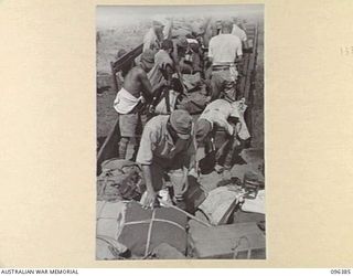 KAIRIRU ISLAND, NEW GUINEA, 1945-09-11. JAPANESE NAVAL MARINES TRANSFERRING THEIR EQUIPMENT AND BELONGINGS FROM THEIR TRUCK TO AN AUSTRALIAN TRUCK FOR TRANSFER TO MUSCHU ISLAND. AS THE ADVANCE ..