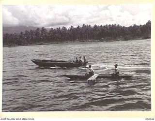 BOUGAINVILLE, 1945-09-17. THE JAPANESE ESCORT BARGE IN NUMA NUMA HARBOUR PASSING A CANOE BEING PADDLED BY TWO JAPANESE. THE BARGE IS NOW RETURNING TO SHORE TO COLLECT THE JAPANESE COMMANDER AFTER ..