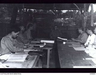 RABAUL, NEW BRITAIN, 1946-03-15. CAPTAIN H. MACDONALD, COMMANDER 5 GROUP CAMP, PRESIDING OVER A CONFERENCE OF JAPANESE UNIT COMMANDERS. THE CAMP IS ONE OF THE THIRTEEN ESTABLISHED AROUND RABAUL FOR ..