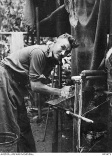 1943-08-09. NEW GUINEA. CAPT. NORMAN SCOTT-YOUNG, OF LANE COVE, N.S.W. OUTSIDE AN ADVANCED DRESSING STATION AT MAT MAT. CAPT. SCOTT-YOUNG WAS A LIGHT HEAVY WEIGHT AMATEUR CHAMPION BOXER. (NEGATIVE ..