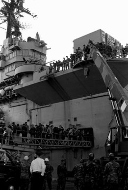 Starboard side view of the amphibious assault ship USS GUAM (LPH-9), as dock hands, news media people and friends wait for the members of the 32nd Marine Amphibious Unit to debark the ship. The Marines were a part of the United Nations peacekeeping force in Beirut, Lebanon