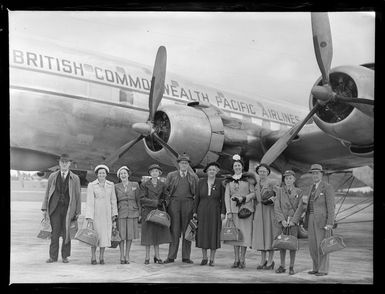 Group of tourists standing in front of a British Commonwealth Pacific Airlines aircraft