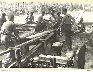 SIAR, NEW GUINEA. 1944-09-11. TROOPS OF THE 113TH INFANTRY BRIGADE WORKSHOPS OPERATING THEIR NEW PORTABLE SAWMILL WHILE CUTTING JUNGLE TIMBER TO BUILD A NEW UNIT CAMP. IDENTIFIED PERSONNEL ARE:- ..