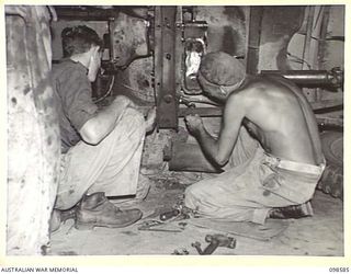 WAU, NEW GUINEA. 1945-10-17. PRIVATE R.C. WILLIAMS (1) AND PRIVATE J.B. FREEMAN (2) MECHANICS OF 5 INDEPENDENT FARM PLATOON, REPAIRING A JEEP. AS THE UNIT IS ISOLATED ALL REPAIRS TO VEHICLES MUST ..