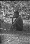 Young man sits on grass, eating