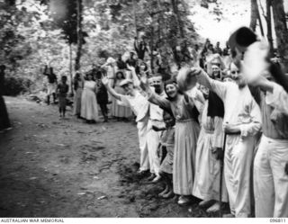 Ramale Mission, Kokopa Area, New Britain. Farewell scene as ten of a group of 300 white former internees prepare to leave Ramale Mission by jeep for the five mile trip to the beach for evacuation ..