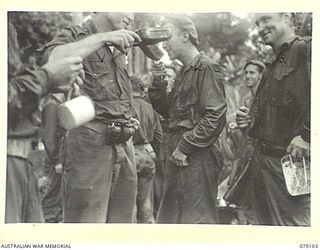 WARAPA AREA, BOUGAINVILLE ISLAND. 1945-02-13. TROOPS OF THE 61ST INFANTRY BATTALION ENJOYING A DRINK OF TEA ON THEIR RETURN FROM A PATROL IN THE WARAPA AREA. IDENTIFIED PERSONNEL ARE:- Q28630 ..