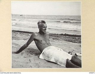 WIRUI BEACH, WEWAK AREA, NEW GUINEA. 1945-08-31. CORPORAL J.H. NIGHTINGALE, 2/1 FIELD AMBULANCE ENJOYING A SPELL ON THE BEACH