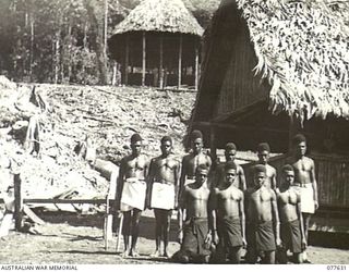 KAMALGAMAN ANCHORAGE, JACQUINOT BAY, NEW BRITAIN. 1944-12-23. NATIVE HOUSEBOYS OUTSIDE THE MESS AT HEADQUARTERS, AUSTRALIAN NEW GUINEA ADMINISTRATIVE UNIT, NEW BRITAIN DISTRICT