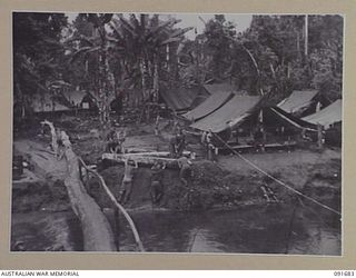 SORAKEN AREA, BOUGAINVILLE ISLAND. 1945-05-04. THE NARGAN RIVER VIEWED FROM 16 FIELD COMPANY, ROYAL AUSTRALIAN ENGINEERS, CAMP. MEN IN THE FOREGROUND ARE PUSHING LOGS FROM THE RIVER FOR USE IN ..