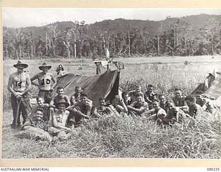 Outdoor group portrait of A Section A Company 2/2 Infantry Battalion. Identified by numbers as follows: (1) NX136461 Corporal (Cpl) Stanley George Hartley from Dubbo, NSW; (2) NX58171 Lance ..