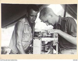 KARAWOP, NEW GUINEA. 1945-07-19. LANCE CORPORAL F.J. LOVELL, REGIMENT SIGNAL TROOP (1) AND CORPORAL K.R. LAHMAN (2), MEMBERS OF 2/6 CAVALRY (COMMANDO) REGIMENT, REPAIRING RADIO EQUIPMENT AT ..