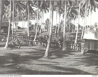 KARKAR ISLAND, NEW GUINEA. 1944-09-18. NATIVES RECRUITED FROM VILLAGES AWAITING ALLOTMENT BY PERSONNEL OF THE AUSTRALIAN NEW GUINEA ADMINISTRATIVE UNIT TO PLANTATIONS