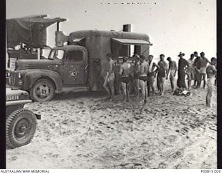 BOUGAINVILLE, C. 1944. AN AUSTRALIAN COMFORTS FUND MOBILE UNIT PROVIDING CUPS OF TEA ON PIVA BEACH. (DONOR A. BARING)