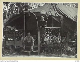 TOROKINA, SOUTH BOUGAINVILLE. 1945-04-28. CRAFTSMAN ALSTON (1) AND CRAFTSMAN SIMASTROM (2), OF TRANSPORT AND LIGHT AID DETACHMENT SECTION, ATTACHED HEADQUARTERS 2 CORPS, STANDING OUTSIDE THE JUNGLE ..