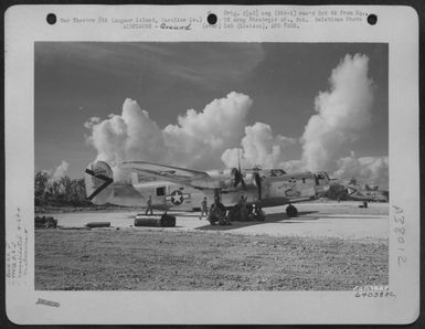 Crew Of The 864Th Bomb Squadron, 494Th Bomb Group, Sit Under The Wing Of Their Plane - The Consolidated B-24 Liberator 'Kuuipo' While Awaiting Orders To Take Off On Bombing Mission To 'Araka Besan' In The Palau Group. This Plane Is Going On A Mission Only (U.S. Air Force Number 64038AC)