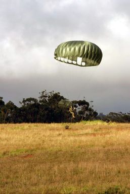 US Navy (USN) Hospital Corpsman Second Class (HM2) Daniel Valez, assigned to the 4th Force Reconnaissance, gently floats to earth while participating in a parachute drop during day combat equipment training at Schofield Barracks, Oahu, Hawaii (HI). (Duplicate image, see also DMSD0602552 or search 040316M9023R127)