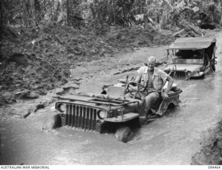 SOUTH BOUGAINVILLE. 1945-07-29. TOW JEEP DRIVERS OF 2/4 ARMOURED REGIMENT HAVING A ROUGH RIDE WHEN THEY HOOKED ON TO A TRACTOR TRAIN RUNNING ALONG THE BUIN ROAD, WEST OF THE OGORATA RIVER. ..