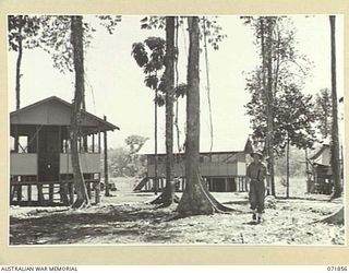 LAE, NEW GUINEA. 1944-03-30. THE DUTY ROOM, OFFICERS' MESS, AND OTHER QUARTERS AT THE 151ST GENERAL TRANSPORT COMPANY. THE THICK, ALMOST IMPENETRABLE JUNGLE WAS CLEARED BY MANUAL LABOUR. VX80911 ..