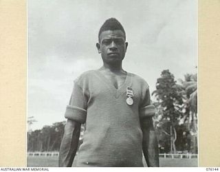 LAE, NEW GUINEA. 1944-09-16. GOMERI, WEARING THE BEM, (CIVIL DIVISION), PRESENTED BY LIEUTENANT GENERAL S. G. SAVIGE, CB, CBE, DSO, MC, ED, GOC NEW GUINEA FORCE. THE CITATION TO THE AWARD READS: ..