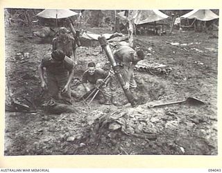 ULEBILUM, NEW GUINEA. 1945-07-11. TROOPS OF A COMPANY, 2/5 INFANTRY BATTALION, PLACING A 4.2-INCH MORTAR BACK INTO ITS PIT AFTER MAINTENANCE PRIOR TO THE ATTACK ON KULAURU MISSION