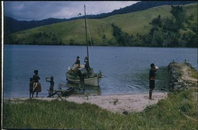 Lisu arrives with spray materials and a village policemen summons help to unload the boat : D'Entrecasteaux Islands, Papua New Guinea, 1956-1959 / Terence and Margaret Spencer