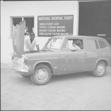 A man observing the engine of a car at Mutual Rental Fleet, Fiji, November 1966 / Michael Terry