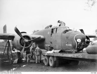 NEW GUINEA. 1943-09-29. CRASHED MITCHELL BOMBER "PI JOE" WHICH CRASHED DURING A "TAKE-OFF" LOADED ONTO A SEMI-TRAILER OF THE UNITED STATES AIR FORCE. IN THIS CRASH BRIGADIER R. B. SUTHERLAND WAS ..