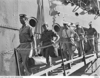 SYDNEY, NSW. 1946-05-09. NAVAL PERSONNEL RETURNING HOME COMING DOWN THE GANGPLANK OF TROOPSHIP DUNTROON AFTER HER ARRIVAL AT CIRCULAR QUAY FROM KURE, MOROTAI AND RABAUL